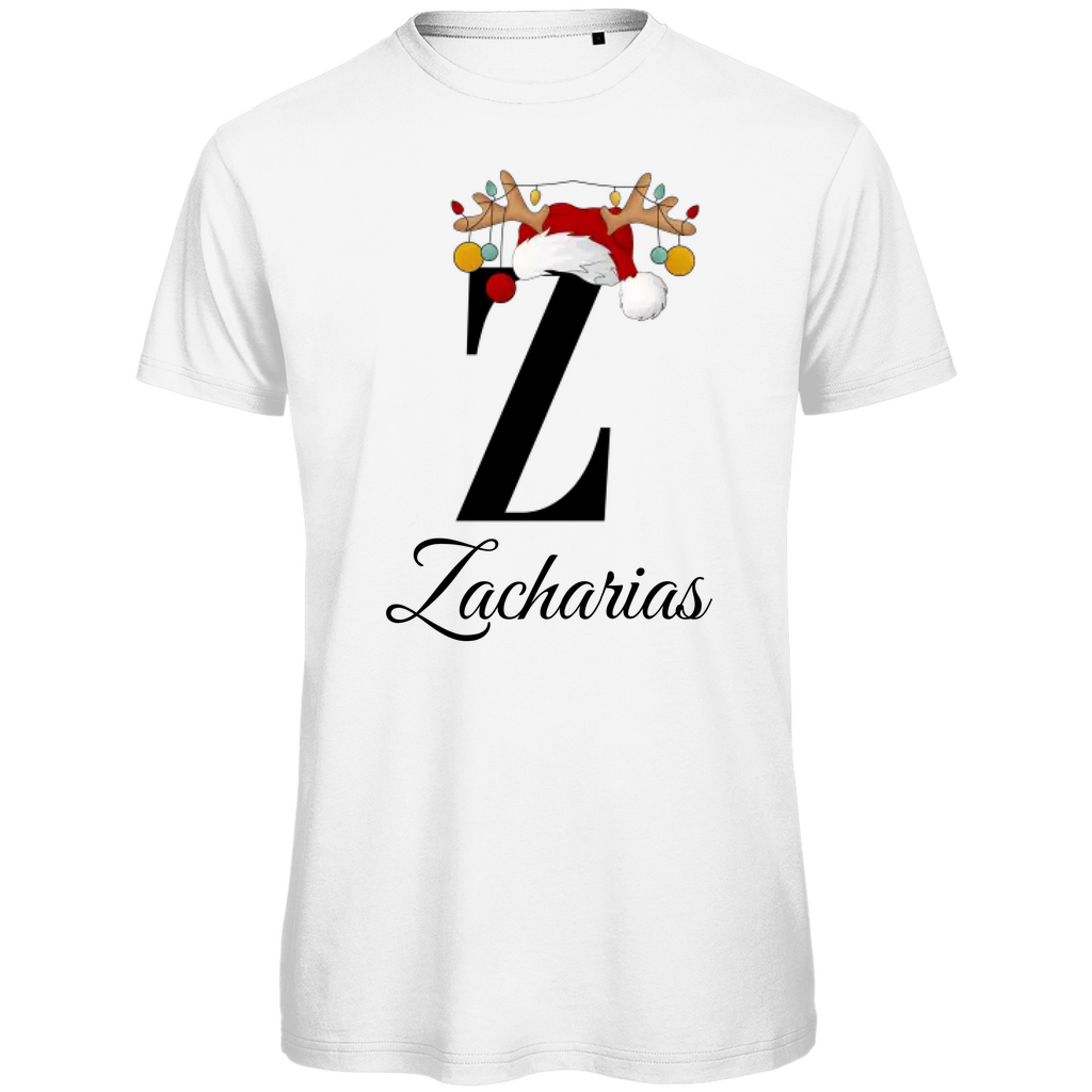 Ein weißes T-Shirt mit einem weihnachtlichen Design, das den Buchstaben „Z“ in schwarzer Farbe zeigt. Der Buchstabe ist mit einem Weihnachtsmann-Hut und Rentiergeweihen verziert, an denen bunte Kugeln hängen. Unter dem Buchstaben steht der Name „Zacharias“ in eleganter, geschwungener Schrift. Das T-Shirt strahlt eine festliche Stimmung aus und ist perfekt für die Weihnachtszeit.