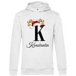 Ein weißer Hoodie mit einem weihnachtlichen Design, das den Buchstaben "K" zeigt. Der Buchstabe ist in schwarz gehalten und mit einem Weihnachtsmann-Hut sowie Rentiergeweihen verziert, an denen bunte Kugeln hängen. Unter dem Buchstaben ist der personalisierte Name "Konstantin" in eleganter, geschwungener Schrift zu sehen. Der Hoodie strahlt eine festliche und personalisierte Stimmung aus und eignet sich perfekt für die Winter- und Weihnachtszeit.