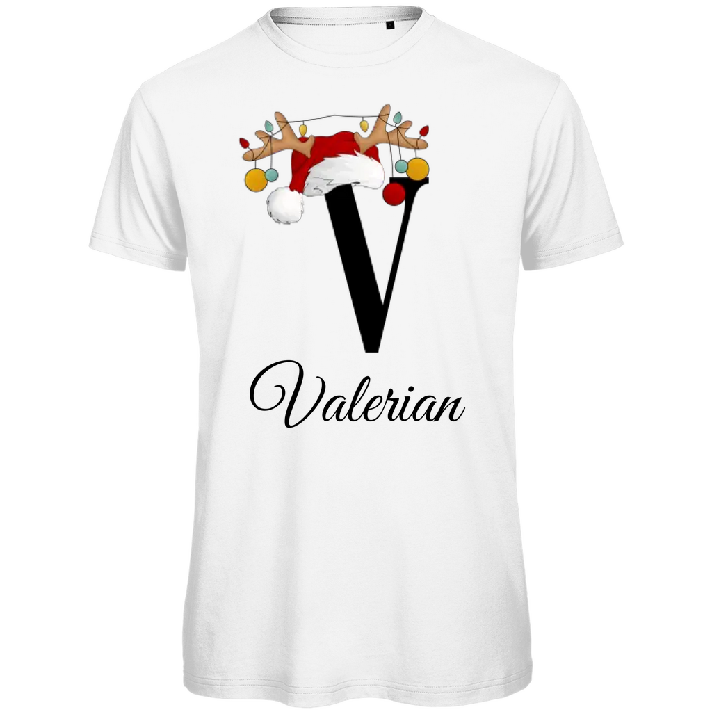 Ein weißes T-Shirt mit einem weihnachtlichen Design. Der große Buchstabe "V" ist mittig auf der Brust abgebildet und trägt einen Weihnachtsmann-Hut sowie Rentiergeweihe, an denen bunte Weihnachtskugeln hängen. Unterhalb des Buchstabens steht der Name "Valerian" in eleganter, geschwungener Schrift. Das Design vermittelt eine festliche Stimmung und ist personalisiert für den Namen Valerian.