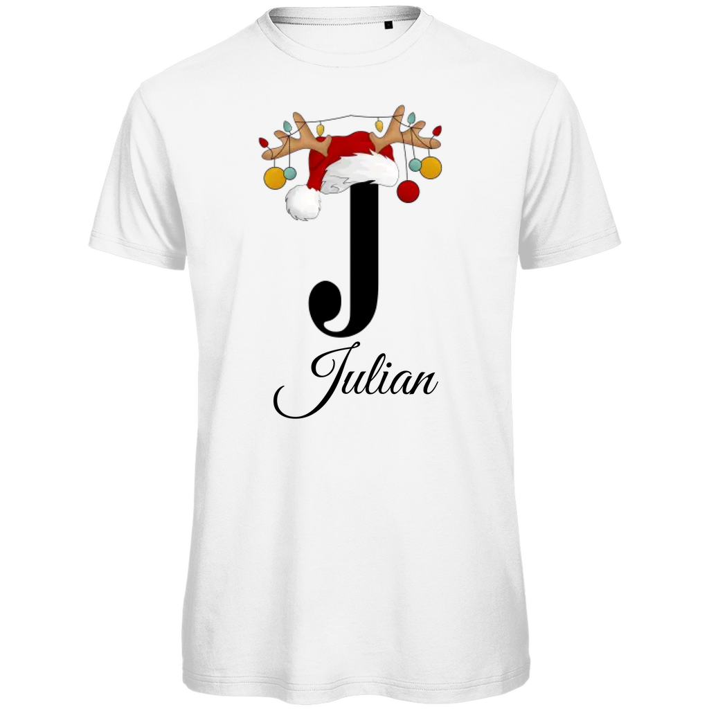 Ein weißes T-Shirt mit einem weihnachtlichen Design. Der große Buchstabe "J" ist mittig auf der Brust abgebildet und trägt einen Weihnachtsmann-Hut sowie Rentiergeweihe, an denen bunte Weihnachtskugeln hängen. Unterhalb des Buchstabens steht der Name "Julian" in eleganter, geschwungener Schrift. Das Design vermittelt eine festliche Stimmung und ist personalisiert für den Namen Julian.