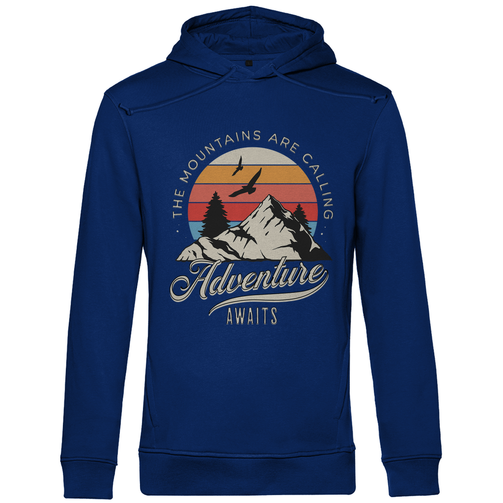 Ein blauer Hoodie mit einem Outdoor-Design, das einen Berg, Bäume und fliegende Vögel zeigt. Im Hintergrund ist ein Sonnenuntergang in warmen Farbstreifen abgebildet. Der Text "The Mountains Are Calling" ist im oberen Bereich des Designs zu sehen, während "Adventure Awaits" in geschwungener Schrift darunter steht. Das Design vermittelt eine abenteuerliche und naturverbundene Atmosphäre, ideal für Liebhaber von Outdoor-Aktivitäten und Bergen.