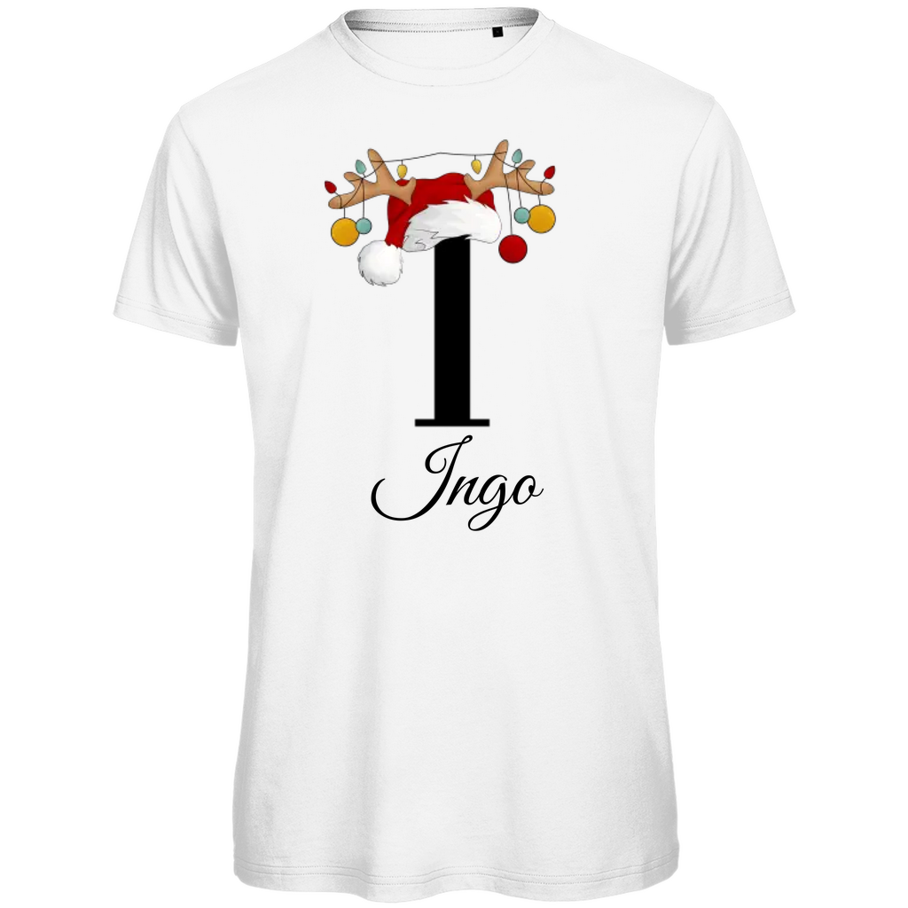 Ein weißes T-Shirt mit einem weihnachtlichen Design. Der große Buchstabe "I" ist mittig auf der Brust abgebildet und trägt einen Weihnachtsmann-Hut sowie Rentiergeweihe, an denen bunte Weihnachtskugeln hängen. Unterhalb des Buchstabens steht der Name "Ingo" in eleganter, geschwungener Schrift. Das Design vermittelt eine festliche Stimmung und ist personalisiert für den Namen Ingo.