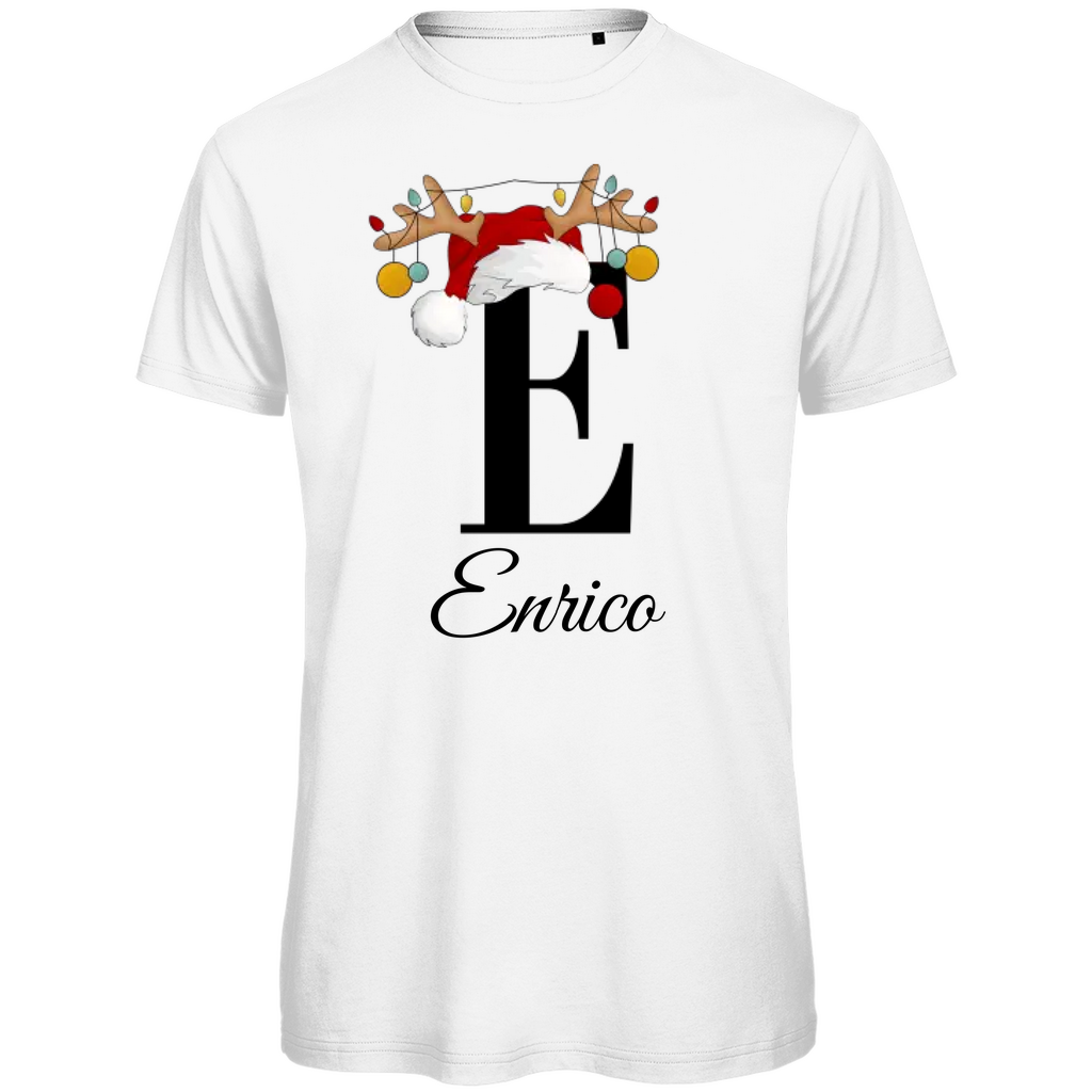 Ein weißes T-Shirt mit einem weihnachtlichen „E“-Design in Schwarz, verziert mit einem Weihnachtsmann-Hut und Rentiergeweihen, an denen bunte Kugeln hängen. Unter dem Buchstaben steht der Name „Enrico“ in eleganter, geschwungener Schrift. Der Name ist personalisierbar, während die Schrift unverändert bleibt. Dieses T-Shirt verleiht eine festliche und personalisierte Note, ideal für die Weihnachtszeit.