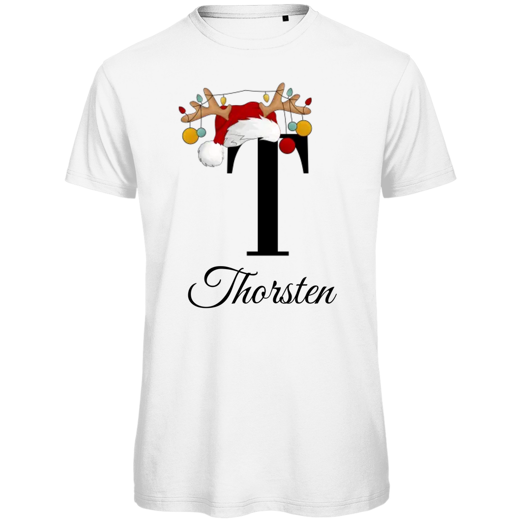 Ein weißes T-Shirt mit einem weihnachtlichen Design. Der große Buchstabe "T" ist mittig auf der Brust abgebildet und trägt einen Weihnachtsmann-Hut sowie Rentiergeweihe, an denen bunte Weihnachtskugeln hängen. Unterhalb des Buchstabens steht der Name "Thorsten" in eleganter, geschwungener Schrift. Das Design vermittelt eine festliche Stimmung und ist personalisiert für den Namen Thorsten.