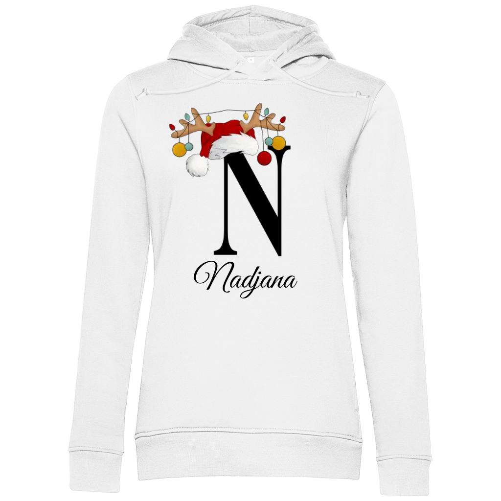 Ein weißer Damen Premium Bio Hoodie mit einem großen schwarzen Buchstaben „N“, verziert mit einem Weihnachtsmann-Hut und Rentiergeweihen, an denen bunte Kugeln hängen. Unter dem Buchstaben steht der Name „Nadjana“ in eleganter, geschwungener Schrift. Der Hoodie strahlt eine festliche und personalisierte Stimmung aus, ideal für die Weihnachtszeit.