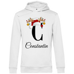 Ein weißer Hoodie mit einem weihnachtlichen Design, das den Buchstaben 'C' zeigt. Der Buchstabe ist in schwarz gehalten und mit einem Weihnachtsmann-Hut sowie Rentiergeweihen verziert, an denen bunte Kugeln hängen. Unter dem Buchstaben ist der personalisierte Name 'Constantin' in eleganter, geschwungener Schrift zu sehen. Der Hoodie strahlt eine festliche und personalisierte Stimmung aus und eignet sich perfekt für die Winter- und Weihnachtszeit.