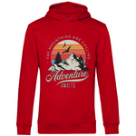 Ein roter Hoodie mit einem Outdoor-Design, das einen Berg, Bäume und fliegende Vögel zeigt. Im Hintergrund ist ein Sonnenuntergang in warmen Farbstreifen abgebildet. Der Text "The Mountains Are Calling" ist im oberen Bereich des Designs zu sehen, während "Adventure Awaits" in geschwungener Schrift darunter steht. Das Design vermittelt eine abenteuerliche und naturverbundene Atmosphäre, ideal für Liebhaber von Outdoor-Aktivitäten und Bergen.