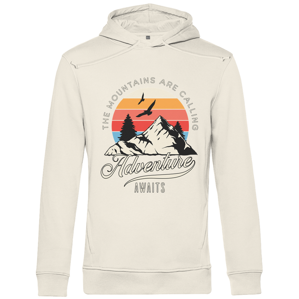 Ein beiger Hoodie mit einem Outdoor-Design, das einen Berg, Bäume und fliegende Vögel zeigt. Im Hintergrund ist ein Sonnenuntergang in warmen Farbstreifen abgebildet. Der Text "The Mountains Are Calling" ist im oberen Bereich des Designs zu sehen, während "Adventure Awaits" in geschwungener Schrift darunter steht. Das Design vermittelt eine abenteuerliche und naturverbundene Atmosphäre, ideal für Liebhaber von Outdoor-Aktivitäten und Bergen.