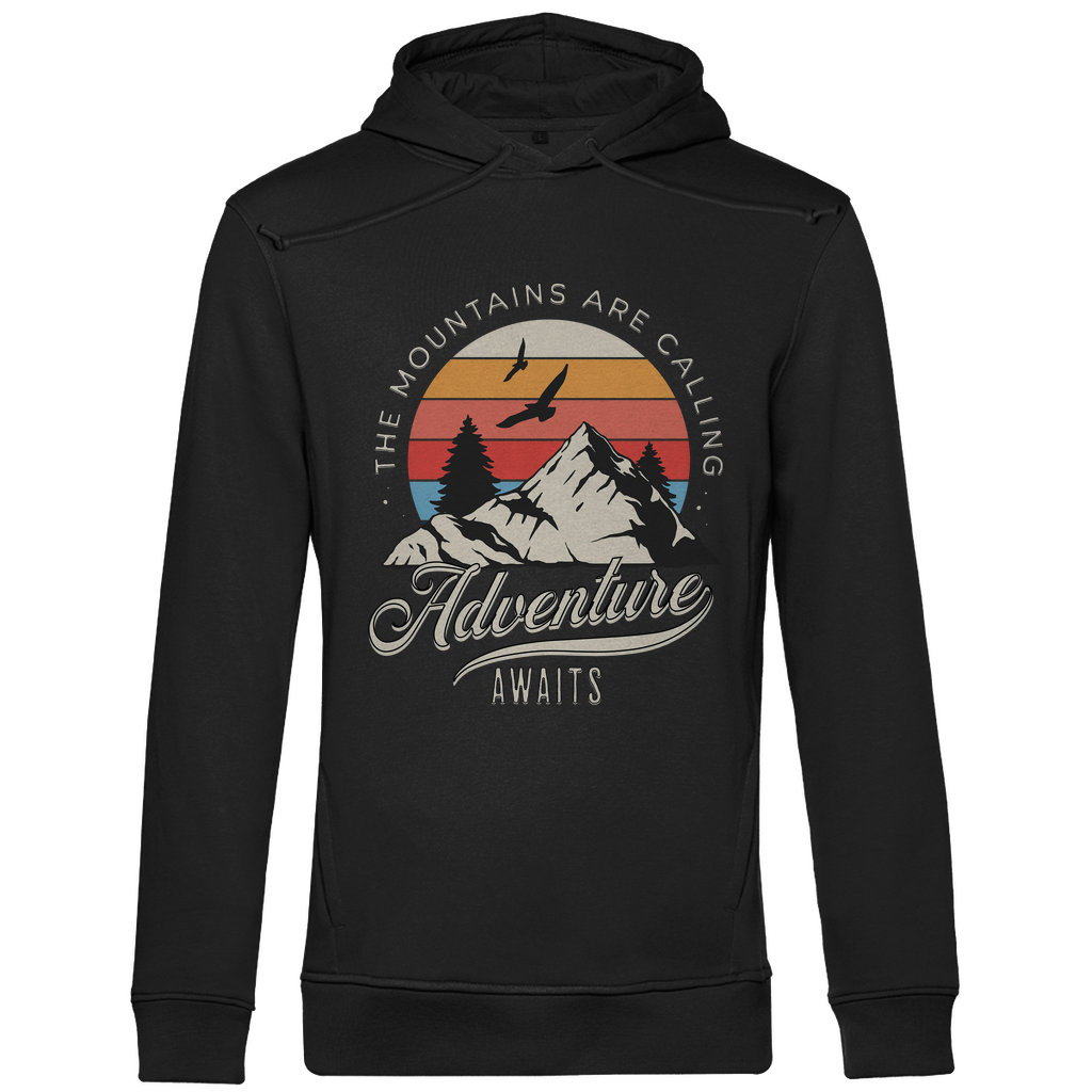 Ein schwarzer Hoodie mit einem Outdoor-Design, das einen Berg, Bäume und fliegende Vögel zeigt. Im Hintergrund ist ein Sonnenuntergang in warmen Farbstreifen abgebildet. Der Text "The Mountains Are Calling" ist im oberen Bereich des Designs zu sehen, während "Adventure Awaits" in geschwungener Schrift darunter steht. Das Design vermittelt eine abenteuerliche und naturverbundene Atmosphäre, ideal für Liebhaber von Outdoor-Aktivitäten und Bergen.