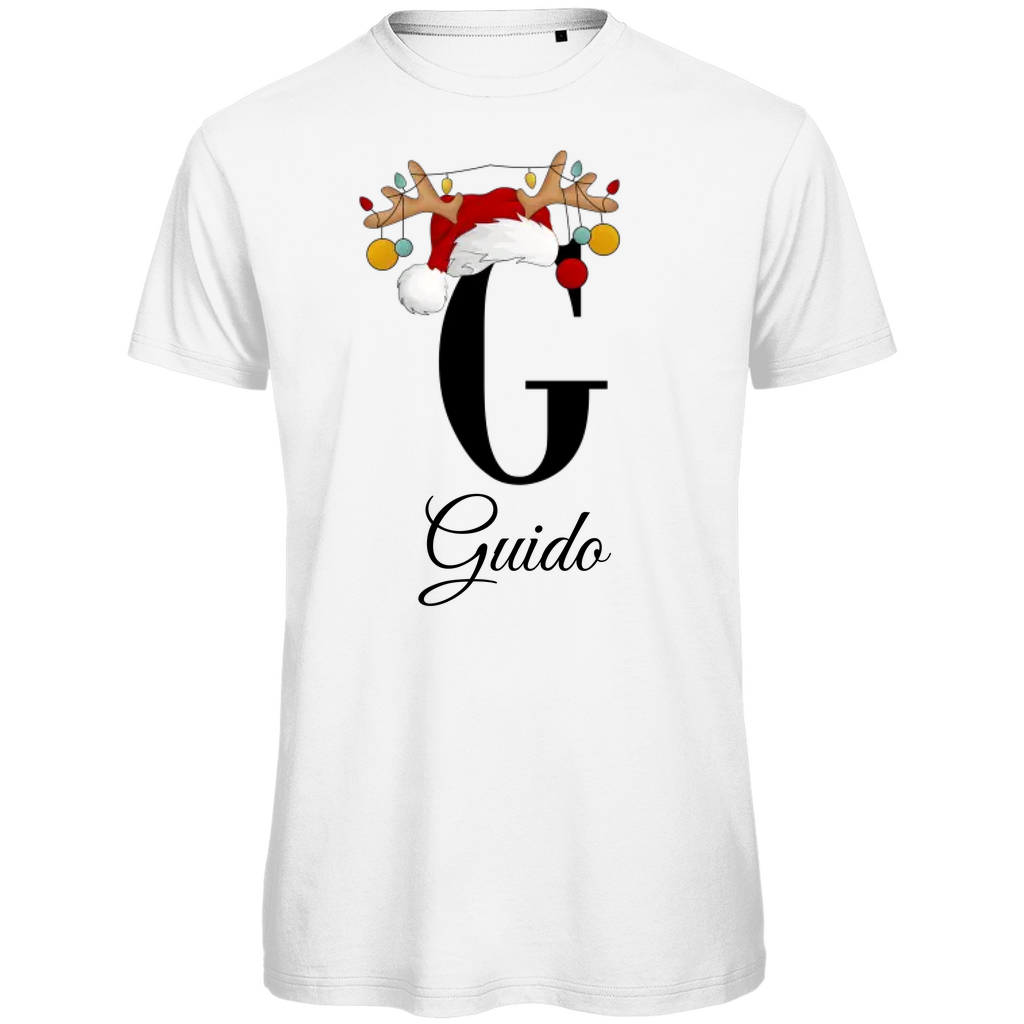 Ein weißes T-Shirt mit einem weihnachtlichen Design. Der große Buchstabe "G" ist mittig auf der Brust abgebildet und trägt einen Weihnachtsmann-Hut sowie Rentiergeweihe, an denen bunte Weihnachtskugeln hängen. Unterhalb des Buchstabens steht der Name "Guido" in eleganter, geschwungener Schrift. Das Design vermittelt eine festliche Stimmung und ist personalisiert für den Namen Guido.