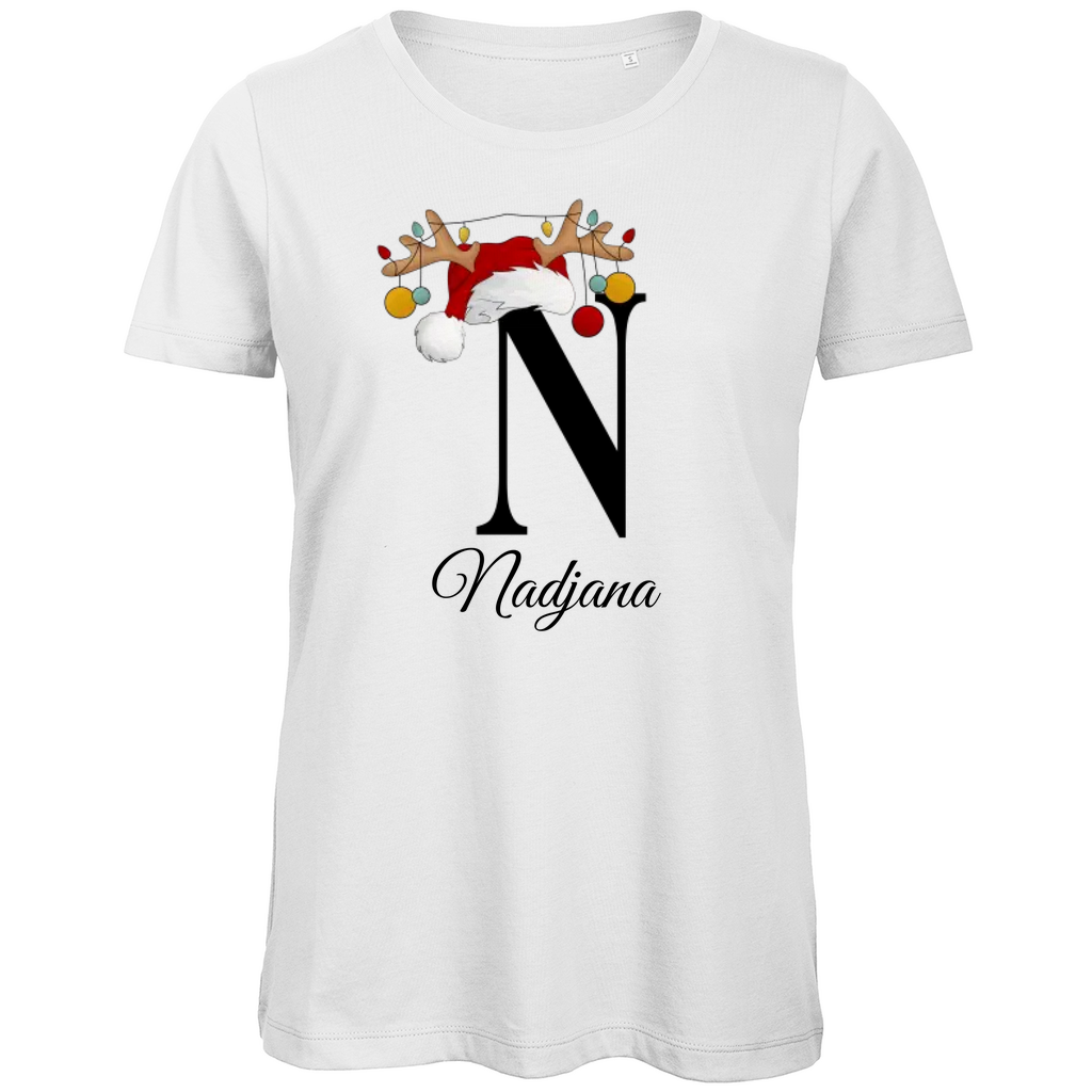 Ein weißes T-Shirt, das den Buchstaben 'N' in Schwarz zeigt. Der Buchstabe ist mit einem Weihnachtsmann-Hut und Rentiergeweihen geschmückt, an denen bunte Kugeln hängen. Darunter ist der Name 'Nadjana' in einer eleganten, geschwungenen Schrift abgebildet.