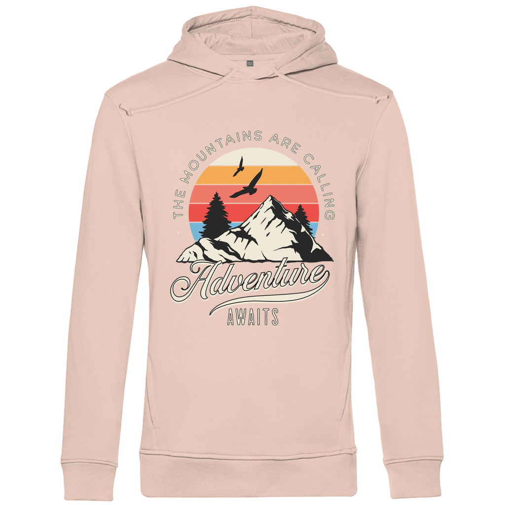 Ein hellrosa Hoodie mit einem Outdoor-Design, das einen Berg, Bäume und fliegende Vögel zeigt. Im Hintergrund ist ein Sonnenuntergang in warmen Farbstreifen abgebildet. Der Text "The Mountains Are Calling" ist im oberen Bereich des Designs zu sehen, während "Adventure Awaits" in geschwungener Schrift darunter steht. Das Design vermittelt eine abenteuerliche und naturverbundene Atmosphäre, ideal für Liebhaber von Outdoor-Aktivitäten und Bergen.